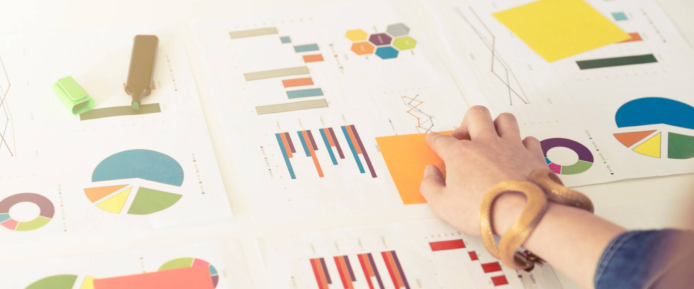 Charts laid out in table with a hand pointing to a data.