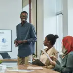 A manager giving a PowerPoint presentation to their employees, using charts to display their message.